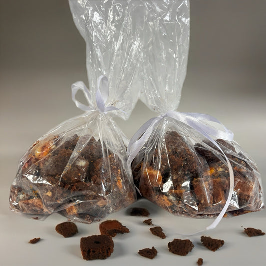 Two clear plastic bags with white ribbons containing brownies on a gray background