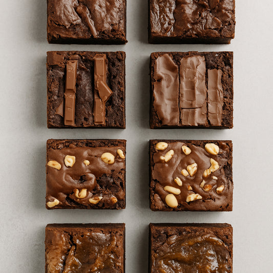 Nine square brownies with different toppings on a light gray background