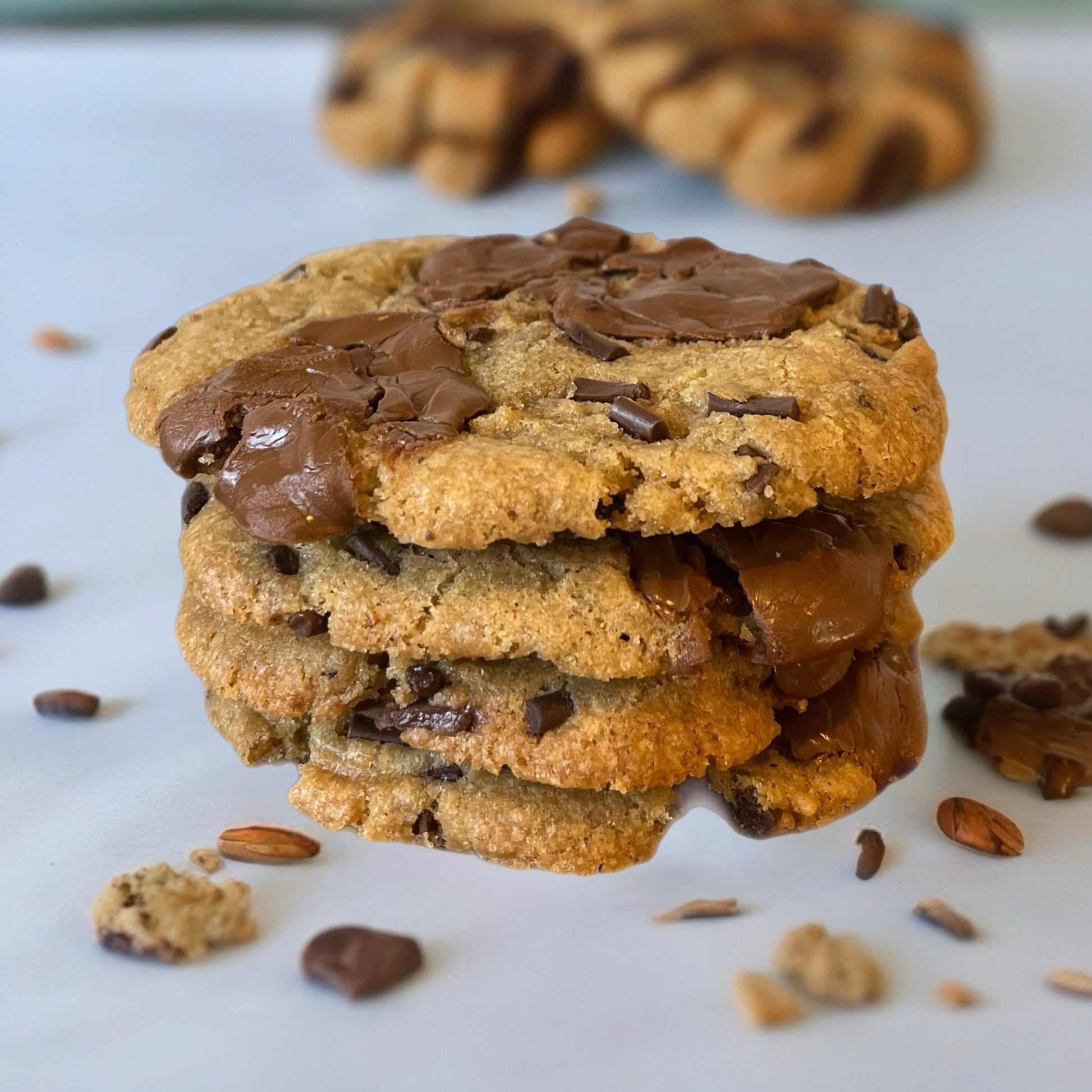 Stack of chocolate chip cookies with chocolate chunks on a white surface