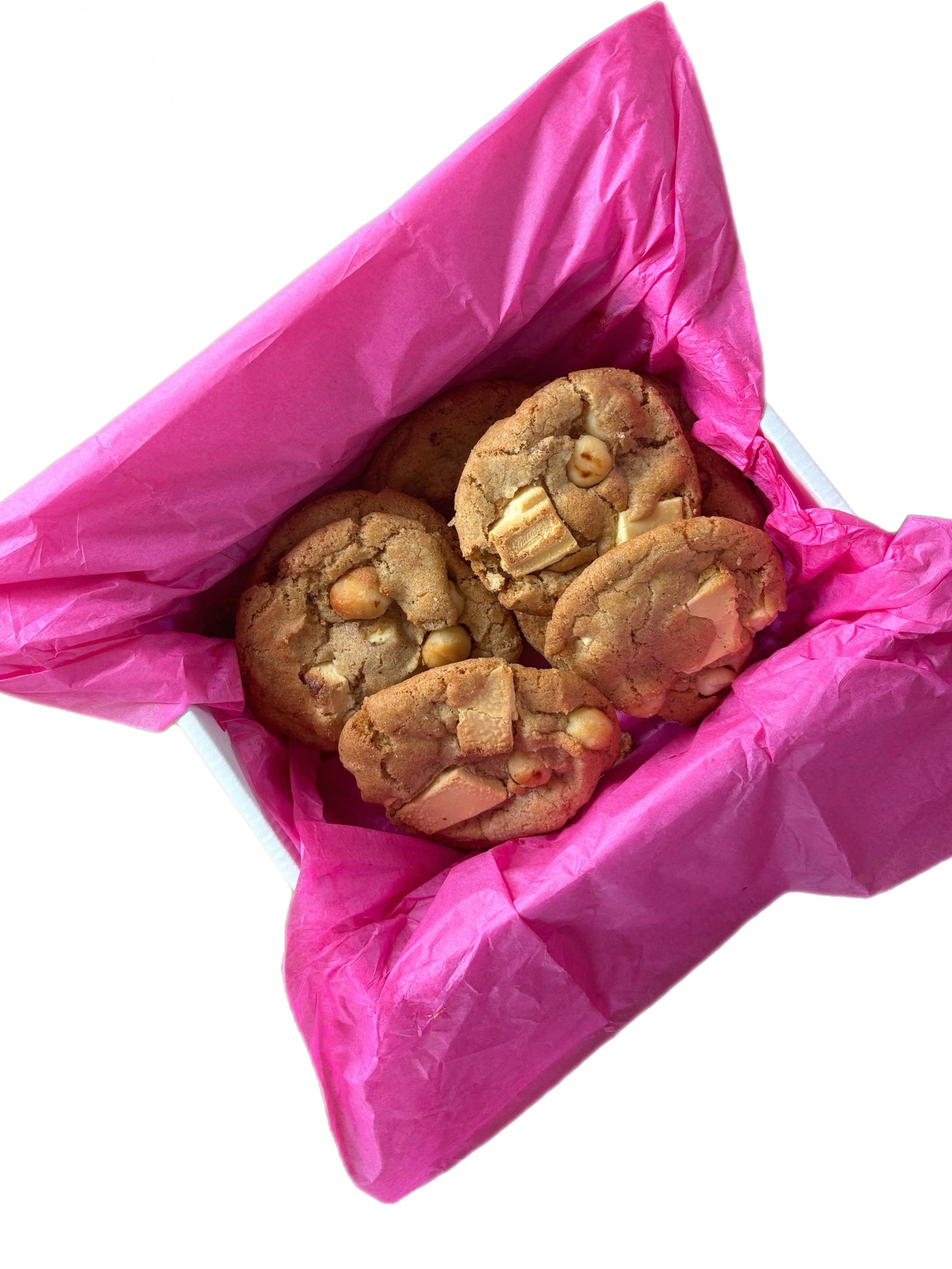 Cookies with visible macadamia nuts, wrapped in pink food paper.